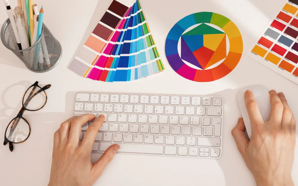 Scrivania di un grafico digitale con tastiera, occhiali e color palette